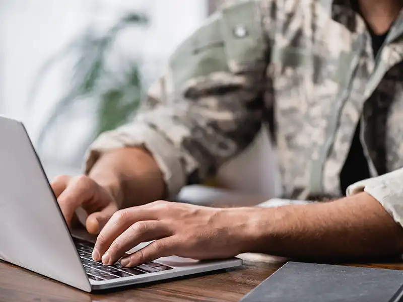 Military personnel using a laptop computer