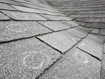 Residential roof with white circles highlighting potential damage