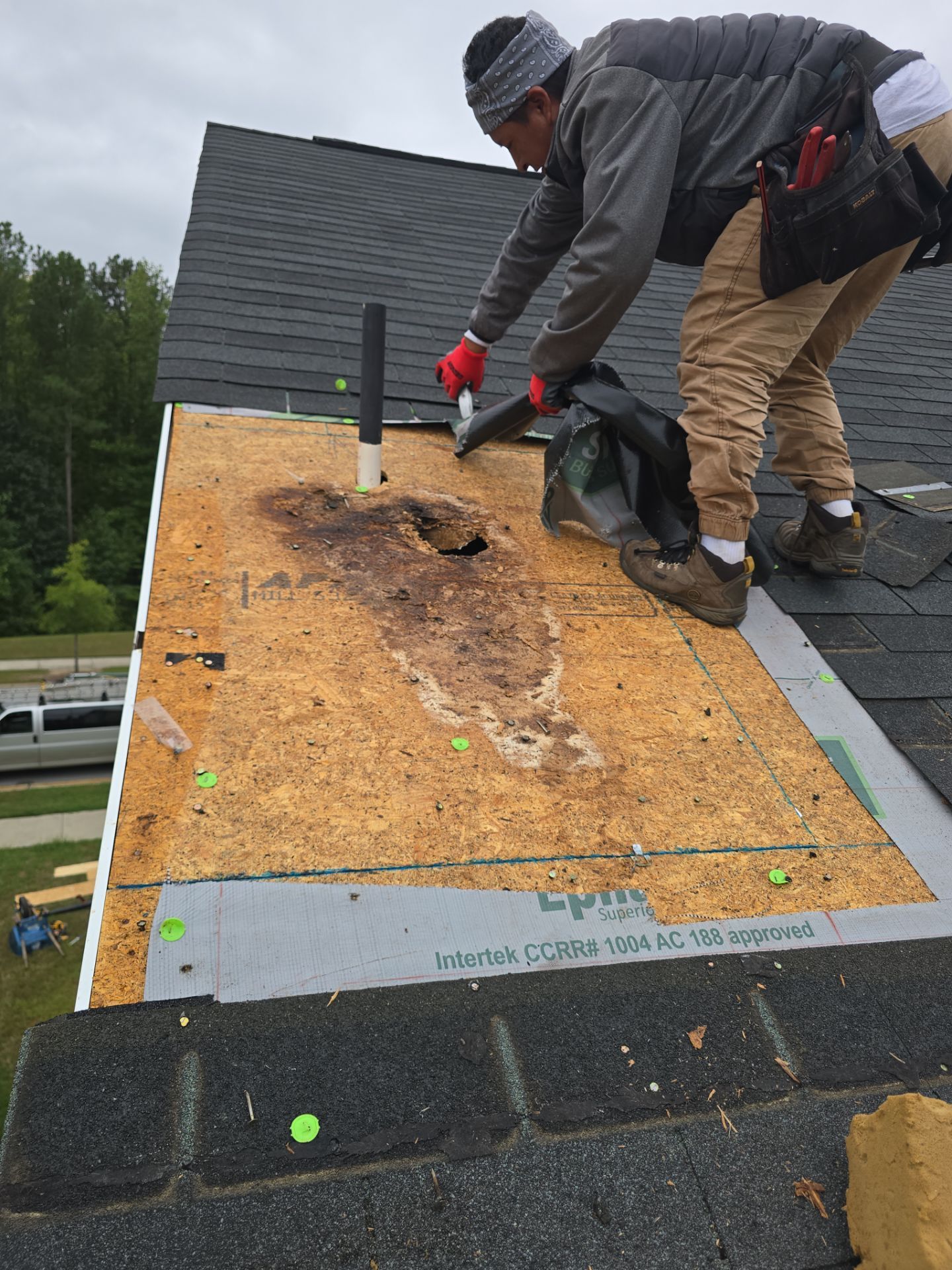 Worker applying sealant to exposed roof hole Raleigh NC