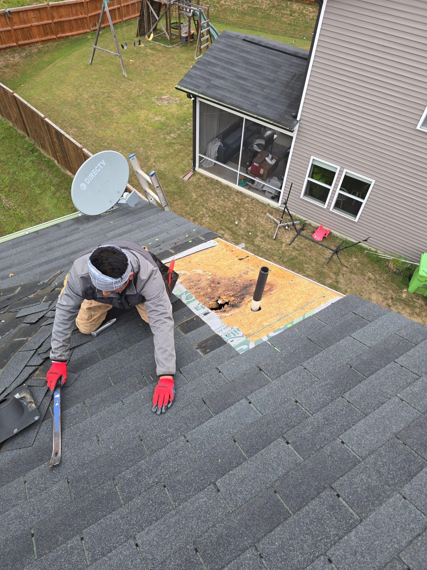 Worker hammering nails into plywood roof patch Raleigh NC